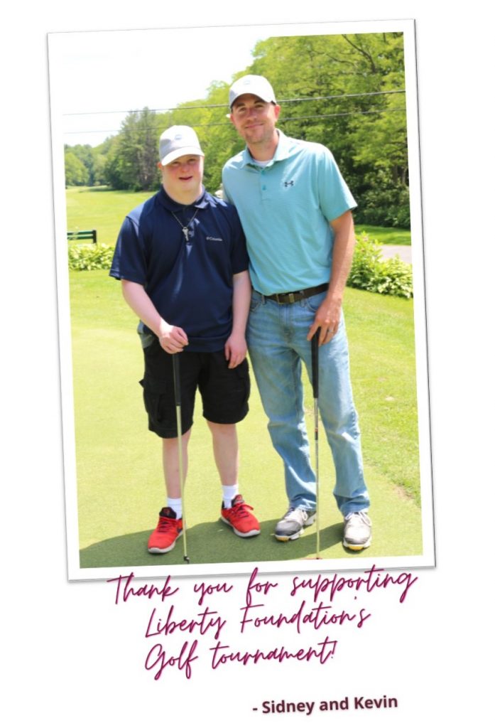 Man supported by Liberty ARC and a male Liberty ARC staff stand on the green of a golf course holding golf club with a thank you for supporting Liberty Foundation's Golf Tournament.