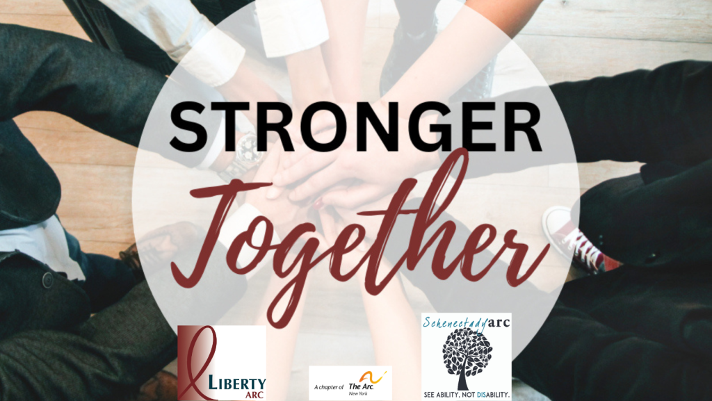 People standing in circle with their hands overlapping each other with phrase Stronger Together.