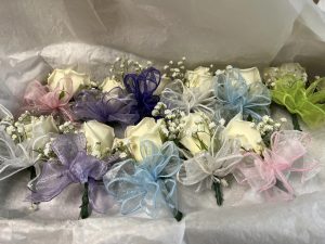Flower corsages with color pastel bows.
