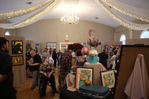Attendees of Liberty ARC's annual art show looking at the various pieces on display.